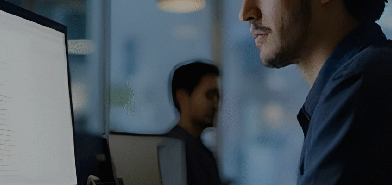 man at work sitting in from of computer with chatgpt on the monitor